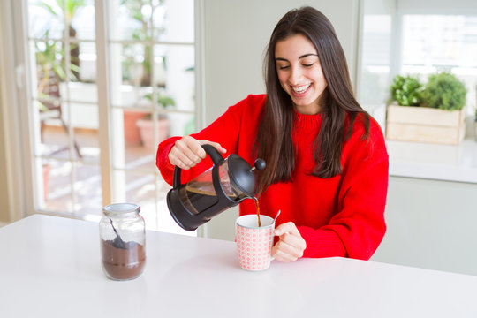 Young beautiful woman making morning coffee smiling, preparing a cup of latte for breakfast