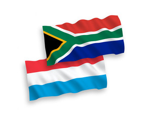 National vector fabric wave flags of Republic of South Africa and Luxembourg isolated on white background. 1 to 2 proportion.