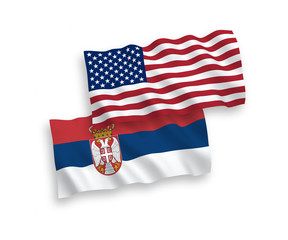 National vector fabric wave flags of Serbia and USA isolated on white background. 1 to 2 proportion.
