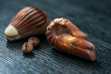 Belgian chocolates on a black wooden background. Photographed close-up.