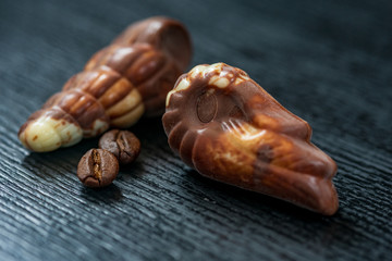 Belgian chocolates on a black wooden background. Photographed close-up.