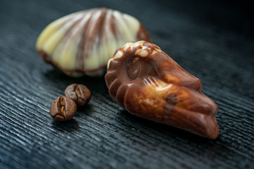 Belgian chocolates on a black wooden background. Photographed close-up.