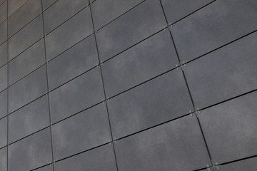 Diagonal view of smooth gray rectangular tile on wall, for background or design