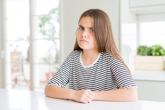 Beautiful young girl kid wearing stripes t-shirt skeptic and nervous, frowning upset because of problem. Negative person.