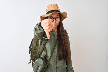 Chinese hiker woman wearing canteen hat glasses backpack over isolated white background looking unhappy and angry showing rejection and negative with thumbs down gesture. Bad expression.