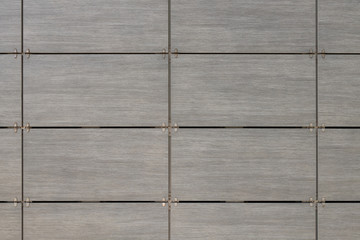 Textured pattern on gray rectangular tiles with dark space in between, front view.