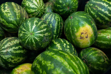 Striped ripe watermelon background ar farmer's market or grocery store. Harvest illustration photo.