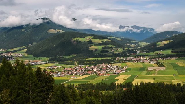 The Alpine villages of Rasun, Valdaora di Centro and Valdaora di Sopra in Val Pusteria as seen from the road towards Passo Furcia. South Tyrol in Italy. Timelapse. 4K UHD Video. Pan camera movement.