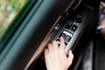 hand using electronic power windows in a car