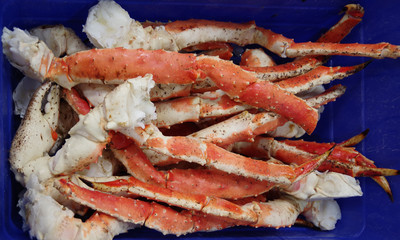 Close-up full frame view of king crab legs in a blue container to be displayed at a market stand