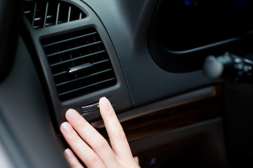 the driver is about to block the air flow from the air conditioner in the car to the face