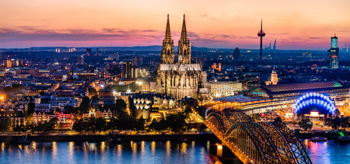 Beautiful night landscape of the gothic Cologne cathedral, Hohenzollern Bridge and the River Rhine at sunset and blue hour in Cologne, Germany - obrazy, fototapety, plakaty