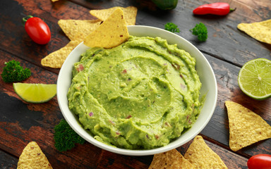 Bowl of fresh Guacamole with nachos chips and herbs. Healthy Vegan, Vegetables food.