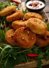 Thai food spicy fish cakes served with pomegranate seeds and wild rocket, arugula salad.