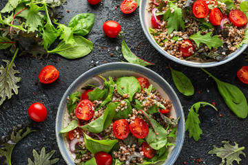 Buckwheat salad with cherry tomatoes, red onion and green vegetables. Healthy diet food