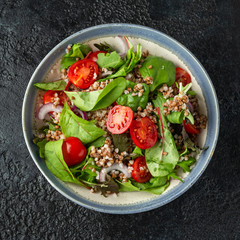 Buckwheat salad with cherry tomatoes, red onion and green vegetables. Healthy diet food