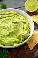 Bowl of fresh Guacamole with nachos chips and herbs. Healthy Vegan, Vegetables food.