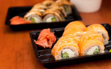 Sushi set in plastic box with salmon, prawns, wasabi and ginger. Traditional Japanese cuisine. Delivery food service concept.
