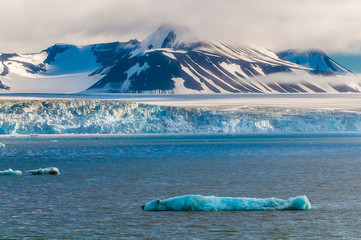 The end of a glacier in the Arctic Circle where it falls into the Arctic Ocean in Hornsund,...
