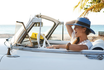 Happy young woman and retro convertible car