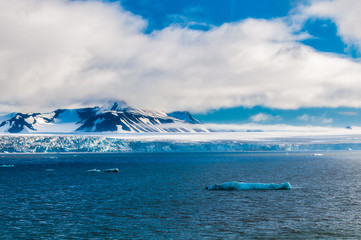 Naklejka premium The end of a glacier in the Arctic Circle where it falls into the Arctic Ocean in Hornsund, Svalbard, Norway.