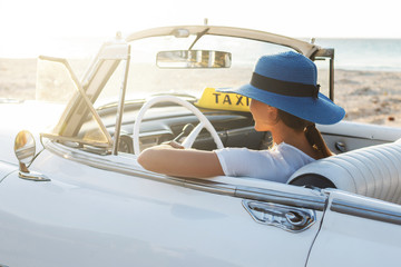 Happy young woman and retro convertible car