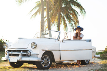 Happy young woman and retro convertible car