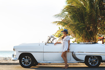 Happy young woman and retro convertible car