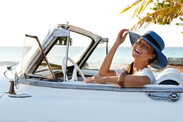Happy young woman and retro convertible car