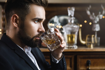 Handsome bearded man with a glass of whiskey