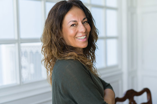 Beautiful middle age woman at home smiling cheerful with arms crossed