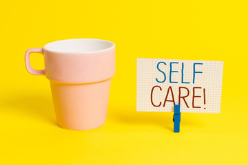 Word writing text Self Care. Business photo showcasing practice of taking action preserve or improve ones own health Cup empty paper blue clothespin rectangle shaped reminder yellow office