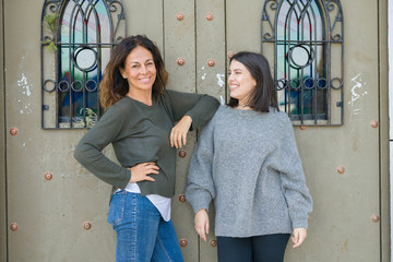 Beautiful family of mother and daughter smiling cheerful, two happy women together leaning on each other as woman power