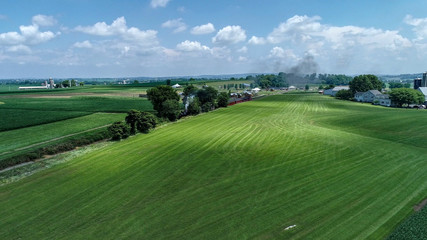 Obraz premium Aerial View of a Steam Train Arriving in Amish Countryside