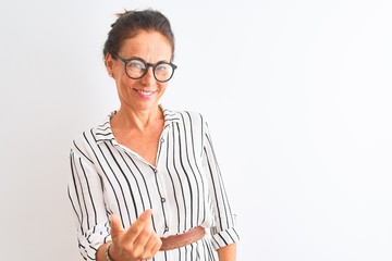 Middle age businesswoman wearing striped dress and glasses over isolated white background Beckoning come here gesture with hand inviting welcoming happy and smiling