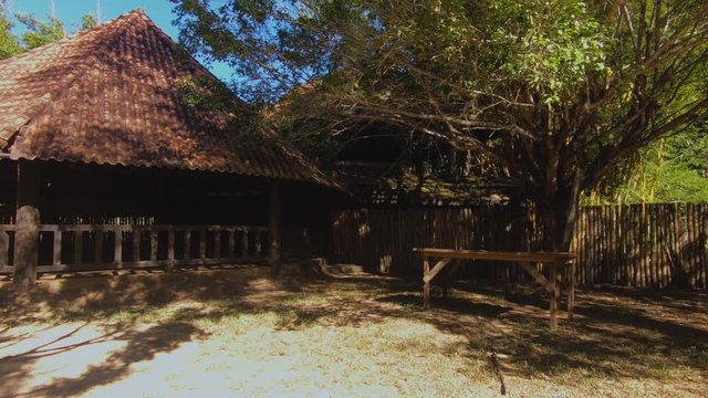 Beautiful Maloka (center, temple) in nature, big trees, wood tables with Waterfall in the background, sandy beach, transparent water and blue sky. Sunny day for relaxation. Beautiful landscape with su