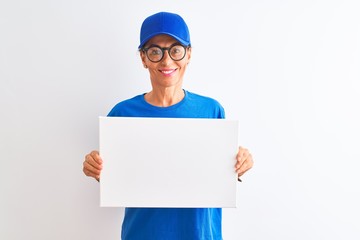 Senior deliverywoman wearing cap and glasses holding banner over isolated white background with a happy face standing and smiling with a confident smile showing teeth
