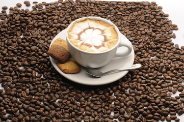 Taza de café con galletas y granos esparcidos