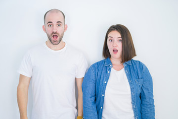 Young couple together over white isolated background afraid and shocked with surprise expression, fear and excited face.
