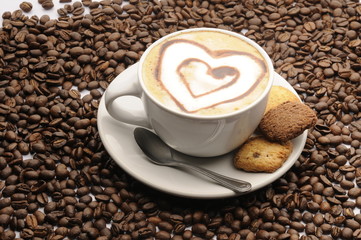 Taza de café con galletas y granos esparcidos