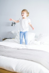 Fototapeta premium Beautiful. toddler child girl jumping on the bed