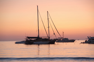 Purple dawning. Yachts in the sea during sunrise