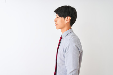 Chinese businessman wearing elegant tie standing over isolated white background looking to side, relax profile pose with natural face and confident smile.