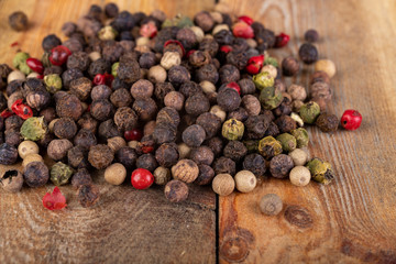 Tasty colorful pepper on a wooden kitchen table. Fresh spices used in home cooking.