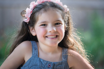 Outdoor portrait of pretty brown hair girl in pink headband
