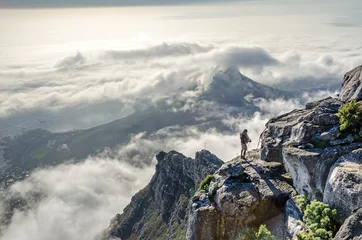 Foto op Plexiglas anti-reflex Tafelberg Lion's Head and Cape Town with low-lying clouds and an extreme sportsman on the Table Mountain Plateau