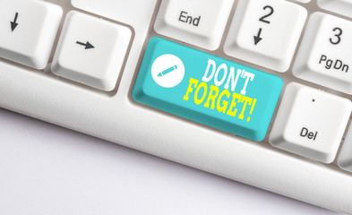 Handwriting text Don T Forget. Conceptual photo used to remind someone about important fact or detail White pc keyboard with empty note paper above white background key copy space