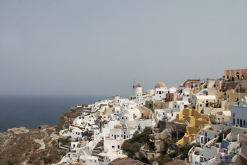 Fototapeta na wymiar White buildings and a mill in Oia City, Santorini, Greece