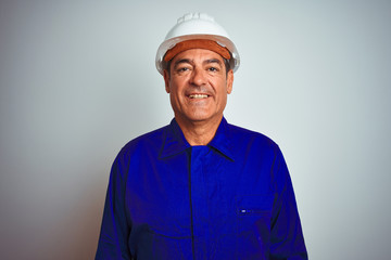 Handsome middle age worker man wearing uniform and helmet over isolated white background with a happy and cool smile on face. Lucky person.