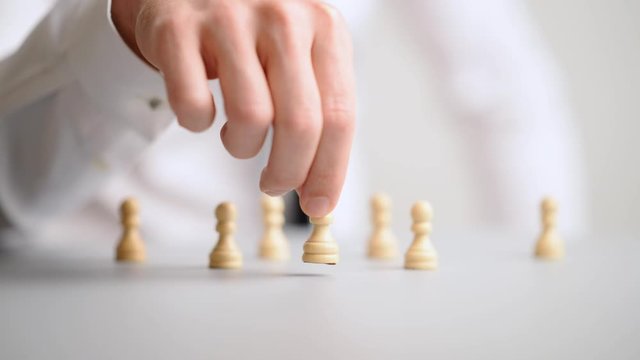 Businessman placing chess piece of pawn in front of the others
